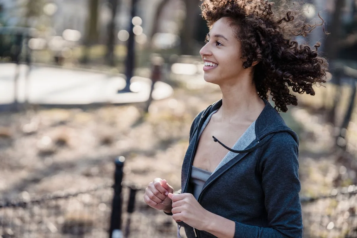 Woman jogging in park in the afternoon — late afternoon physical energy peak
