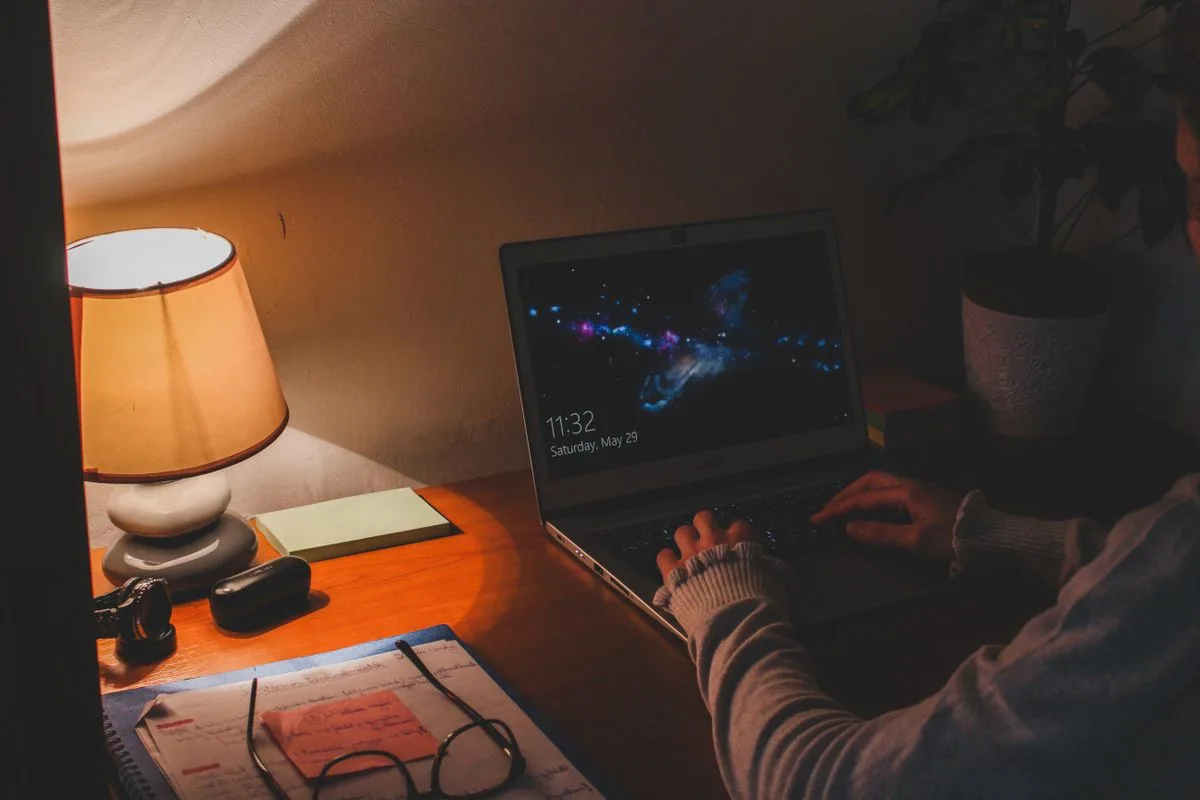 Warm ambient workspace with laptop and lamp in the evening — evening chronotype work schedule